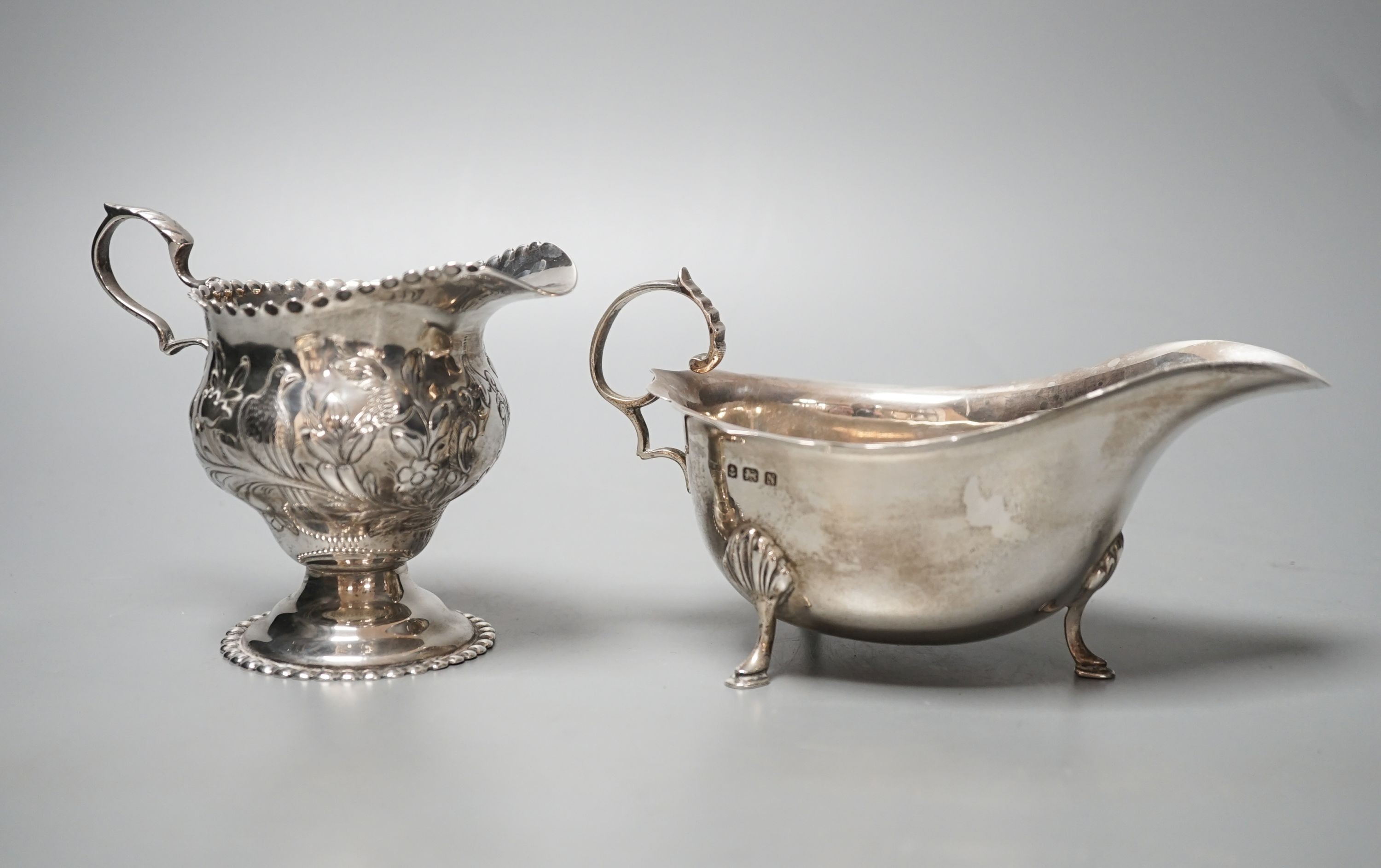 An Edwardian silver cream jug, Chester, 1904 and a late silver sauce boat, 9.5oz.